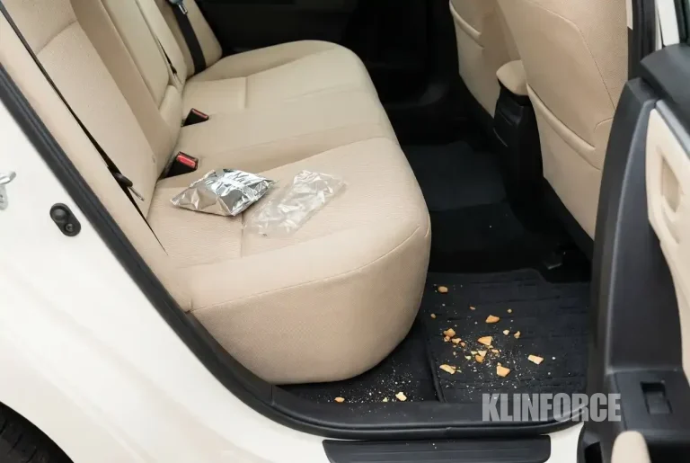Kabin mobil dengan remah makanan di karpet dan bungkus jajanan di kursi