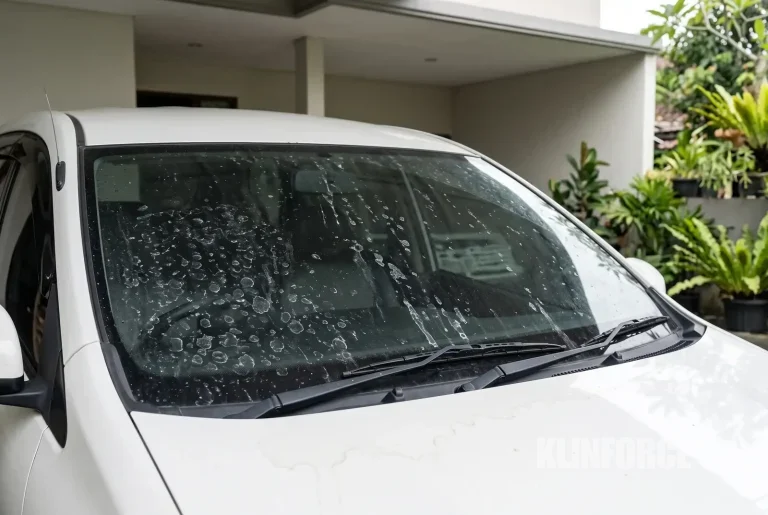 Kaca depan mobil buram dengan bercak jamur dan bekas air hujan